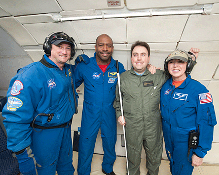 Dominic Del Rosso, Leland Melvin, Mark Riccobono and Terry Lee smile at the camera while in the aircraft used to simulate weightlessness.