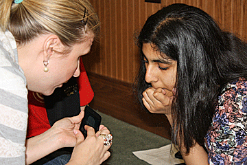 Briley Pollard teaches Seema Khowaja to use the iPod Touch.
