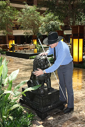 Brad Loos examines a Foo Dog (guardian lion) sculpture. This is the male lion of the pair, identifiable because his paw rests on the world.