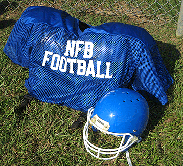 A football jersey and helmet on the ground prior to action