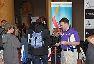 Mark Riccobono hands out I love the Blind Driver Challenge bumper stickers to children waiting in line to try their hand at the BDS.