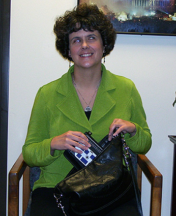 Audrey Farnum slipping her Braille display into one of her many new purses.