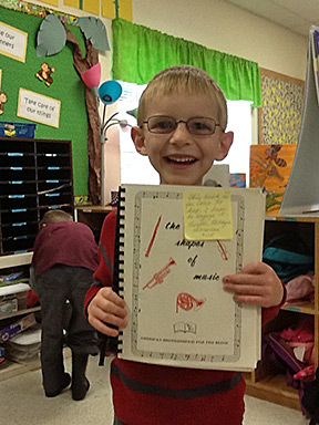 Caleb proudly shows off The Shapes of Music, the Twin Vision™ book he recently received.