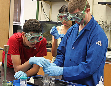Hoby Wedler demonstrates one of the labs to two of his chemistry students.