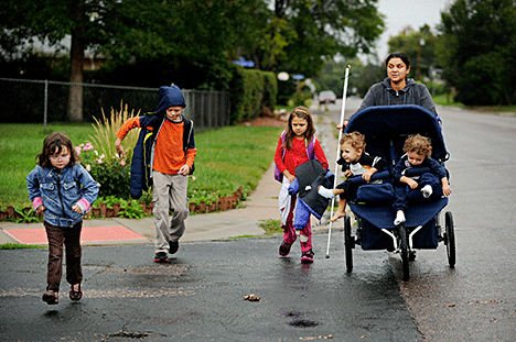 Ena crossing the street with her five sighted children