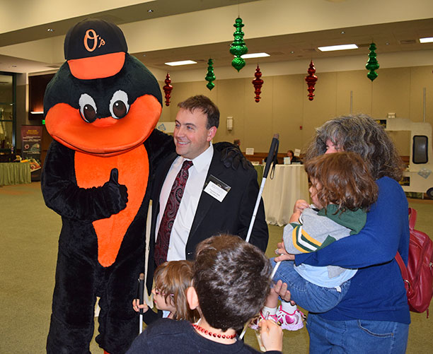 Mark Riccobono poses with the Oriole bird while his family looks on.