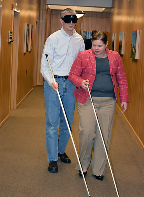 Natalie Shaheen leads one of the participants in the Greater Baltimore Committee Leadership Seminar in a cane travel exercise.