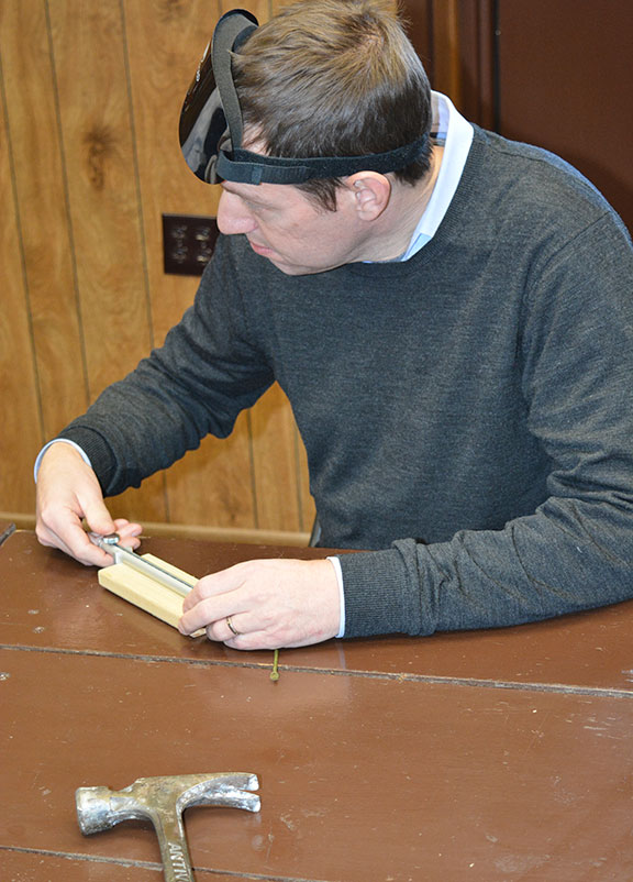 Seminar participant uses a click ruler to measure a piece of wood.