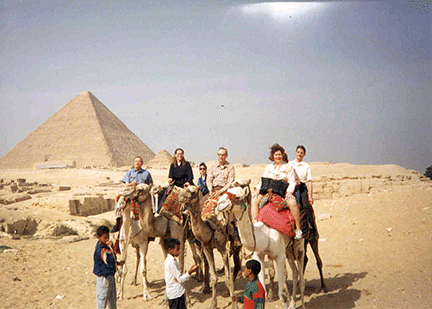 During the General Assembly meeting of the World Blind Union in Cairo in 1992, several NFB leaders and staff go for a camel ride in the desert. Left to right can be seen Kenneth Jernigan, Mary Ellen Jernigan, Patricia Miller, Donald Capps, and Betty Capps. Behind Mrs. Capps, Marc Maurer shares a camel with Pat Maurer.