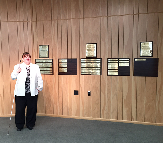 Ellen Ringlein stands next to the new exhibit in the Jacobus tenBroek Library