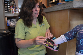 Melissa Riccobono attaches bells to her daughter&rsquo;s shoe