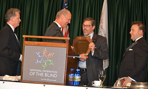 Jim Gashel hands Tristan Denley the final Newel Perry Award, flanked by Marc Maurer and Mark Riccobono.