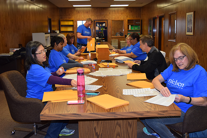 The entire Nielsen Cares team works together on a Braille Pals mailing