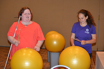 Jessica Beecham (right) teaches cardio drumming to an NFB member.