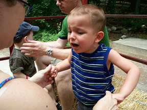 A distressed Ivan holds mother�s hands on a hayride.