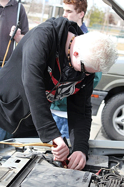 A student learns to recharge a car battery.