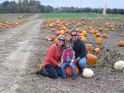 Layla Hildenbrand and her parents gather pumpkins
