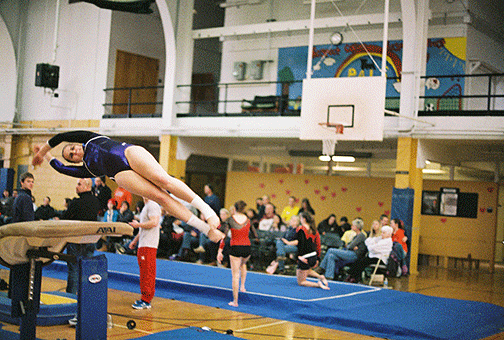 Horizontal to the ground, Rose Sloan vaults over a horse.