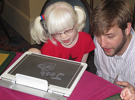 Josh Coffee of E.A.S.Y. LLC shows a picture to a young girl.