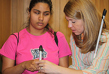 Mary Jo Hartle shows a young girl how to hold her cane.