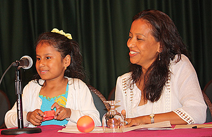 Raveena Alli at the podium with her proud mom looking on