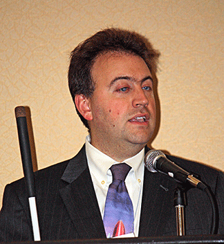 Mark Riccobono stands at the convention podium.