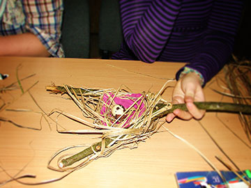 A child&rsquo;s hand examines a human-made replica of an oriole&rsquo;s nest.