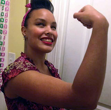 Precious Perez poses, showing her muscles.