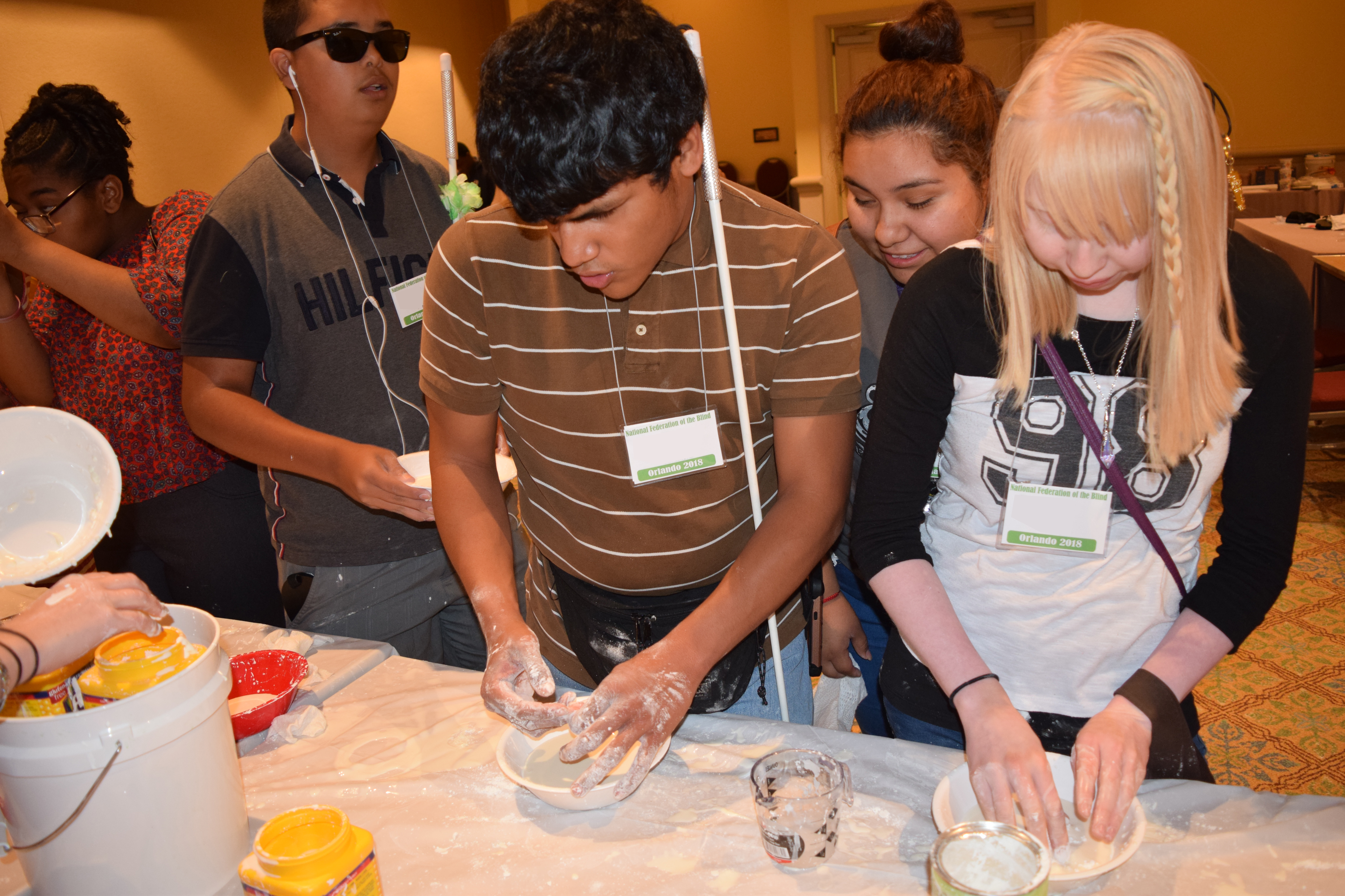 Juan Ramon Garcia and Raelencia Neztsosie mix cement in a bowl.