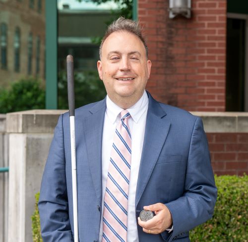 President Riccobono smiles with his membership coin in hand.