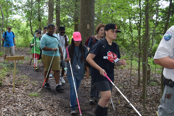 A wilderness guide leads Youth Slam participants through a forest trail.