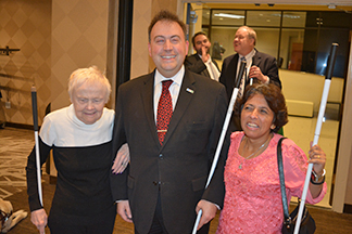President Riccobono stands and smiles with Diane McGeorge and Buna Dahal during 2019 Washington Seminar reception