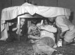 Photo of four NFB campers playing in the table tent they have constructed in the NFB Camp room. 