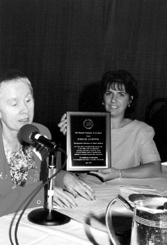 Sharon Maneki reads the text of the plaque while Marlene Culpepper displays the award.