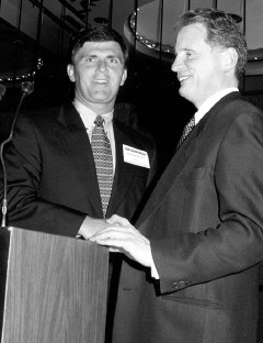 Congressman Robert Ehrlich shakes hands with President Maurer at the podium.