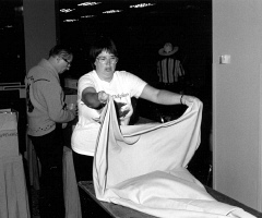 Peggy Chong spreads a cloth over a table in the exhibit hall.