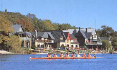 A view of a racing scull on the Schuykill River with Boathoise Row visible in the Background.
