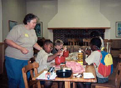 Loretta White supervises campers as they make individual pizzas at tables in the Harbor Room.