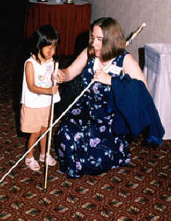 Sheila Koenig instructs Winona Brackett at the Braille Carnival.
