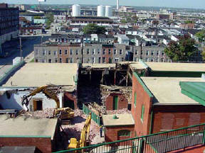Two track hoes move in and begin taking down the old Globe Poster building.