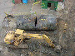 A giant tank lies here beside a track hoe.  A temporary cable stretches across the scene above the track hoe to provide power to the fire protection system.