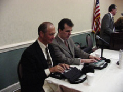 Jim Gashel and Jim McCarthy work on their electronic notetakers at the head table while President Maurer addresses the crowd.
