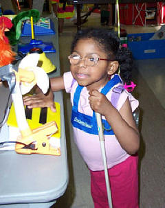 All kids enjoy playing with new toys.   Here Mikaella Besson (Massachusetts) explores a tableful of fun.