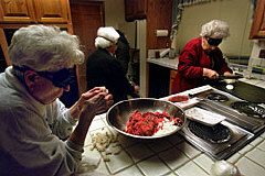 Ruth Hirschfeld, left, and Hazel Phillips prepare food while blindfolded as part of a week-long retreat program teaching seniors who are losing their sight to cope with blindness.   Those with some remaining vision wore sleepshades for the lessons.