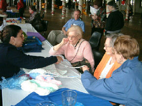 BISM volunteer Johnna Harrison shows several seniors alternative techniques for knitting.