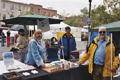 Greater  Baltimore Chapter members Robert Lay, Aloma Bouma, Maurice Peret, and Robert Jaquiss arrange games and literature on the chapter's information table for the Fells Point Fun Festival.
