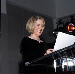 A smiling Donna Hamilton at the podium