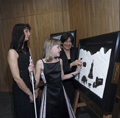 Macy McClain of Ohio explores the Everest Expedition display with the help of artist Ann Cunningham while Crystal McClain, Macy's mother, looks on.