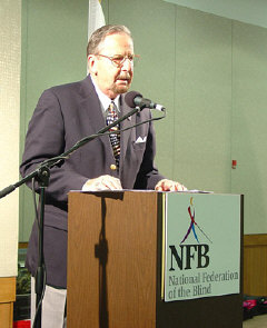Alan Walden, WBAL radio announcer, speaks from the podium.  He told his audience that he uses two hearing aids because of age-related hearing loss.   He urged seniors not to be discouraged by complications like vision loss but to get on with their lives.