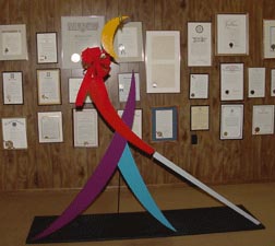 The large model of Whozit that comes to conventions is crowned with tinsel and sports a large bow on his cane arm.